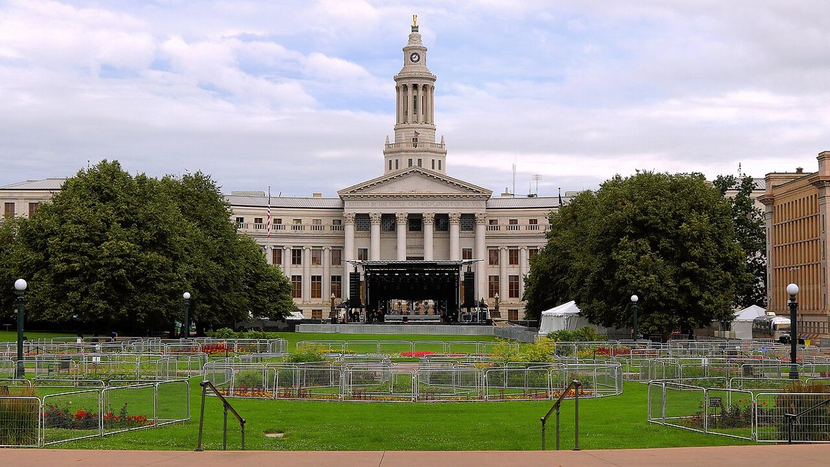 Colorado State Capitol gold dome viewed from Civic Center Park Denver with civic fountains and park benches in foreground